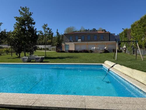 a swimming pool in front of a house at Quinta de Sub-Ribas, ideal para famílias in Vizela