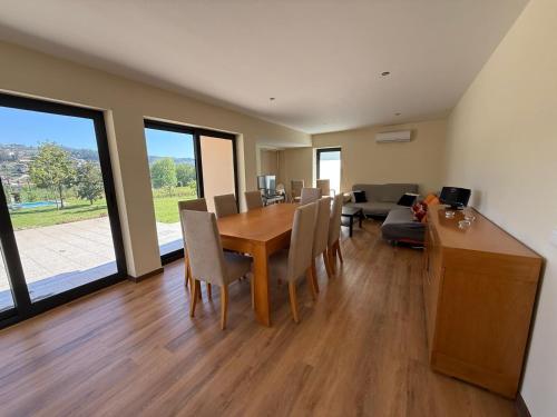 a dining room with a table and chairs and a couch at Quinta de Sub-Ribas, ideal para famílias in Vizela