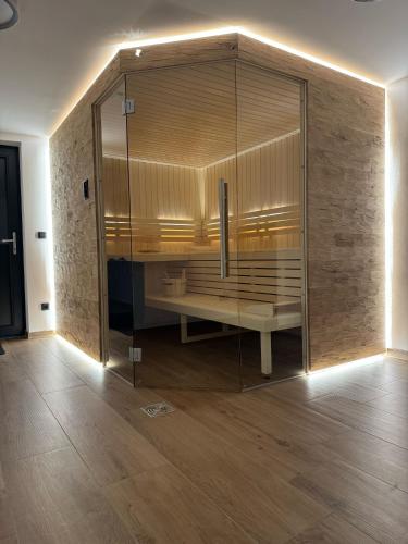a large glass shower with a bench in a room at Spessart Chalet in Dammbach
