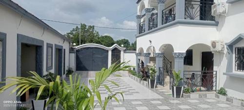 a courtyard of a white building with potted plants at Cutting Edge Guest House in Daranka