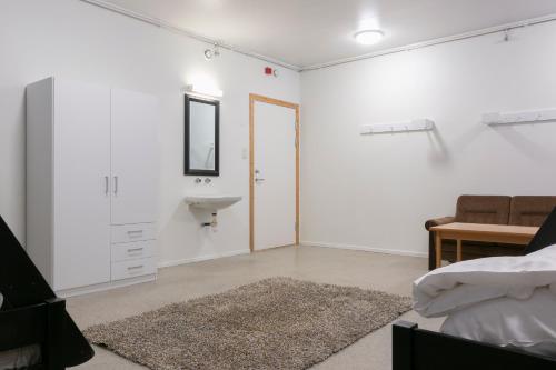 a bedroom with white walls and a sink and a bed at Senja Fjord Lodge in Senja