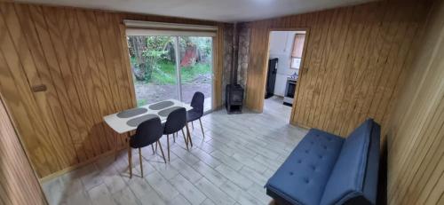 a room with a table and chairs and a stove at Cabaña interior en el centro de llanquihue in Llanquihue