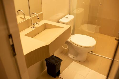 een witte badkamer met een wastafel en een toilet bij Apart Hotel Roda Viva in Abaeté