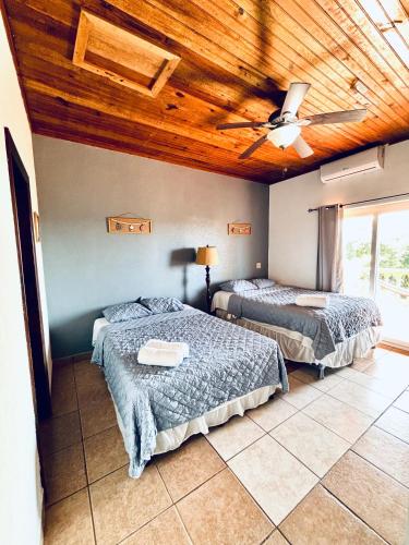 a bedroom with two beds and a ceiling fan at Sunset Views Apartment, West End in West End