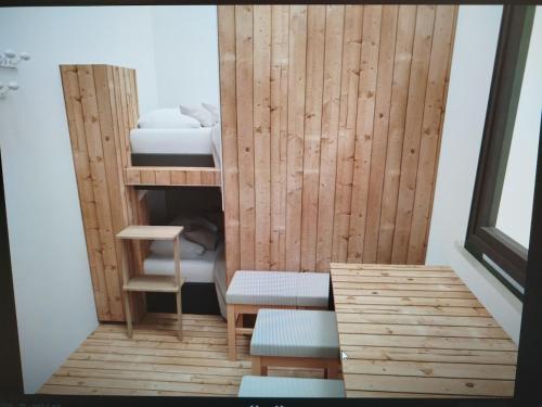 a small room with bunk beds and a table and benches at Schlaffass und Tiny House am See, Spa mit Sauna und Hot Tub, angeln, Boot, Natur in Twist