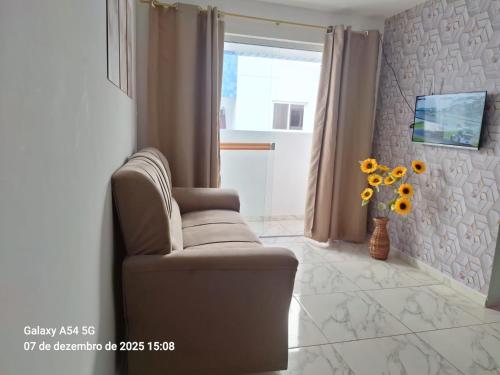 a living room with a chair and a vase of flowers at New apartment in João Pessoa in João Pessoa