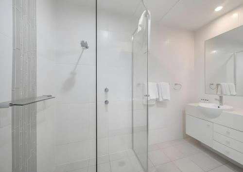 a white bathroom with a shower and a sink at Sea Salt Escape - 2 BEDROOMS - Oaks Port Stephens Pacific Blue Resort in Salamander Bay