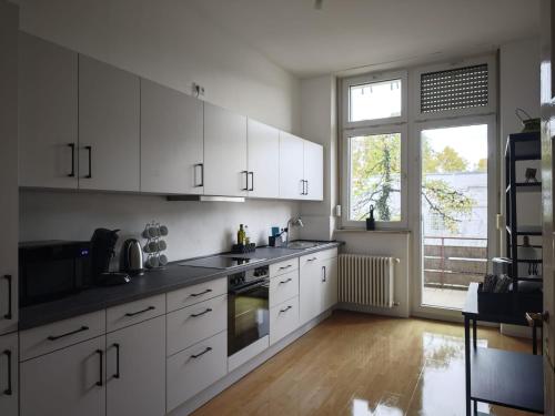 Una cocina con gabinetes blancos y una ventana grande. en DUK42a, en Karlsruhe