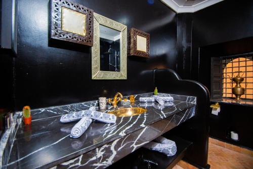 un baño con lavabo y espejo en Riad Ta'achchaqa, en Marrakech
