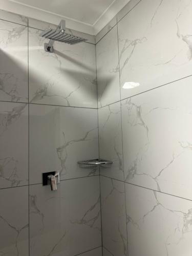 a bathroom with a shower with marble walls at Pendleberry Grove 90 in Bela-Bela