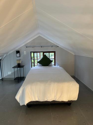 a large white bed in a room with a window at Pendleberry Grove 90 in Bela-Bela