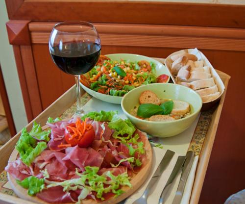 a table with a plate of food and a glass of wine at eco Hotel Milano & BioRiso Restaurant in Milan