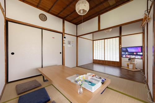a living room with a table and a tv at 温故知新 in Minamiboso