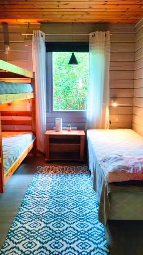 a bedroom with two bunk beds and a window at Brusta Stugor in Ödkarby
