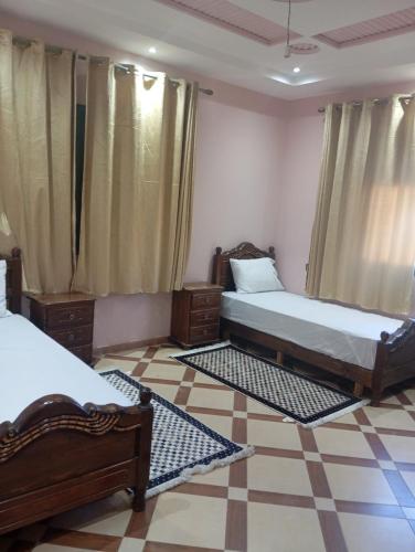 a bedroom with two beds and a tiled floor at Atlas stay in Fez