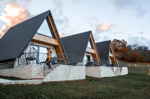 a house with triangular roofs with a person standing on the balcony at Monte zone in Žabljak