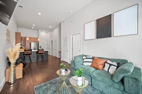 a living room with a green couch and a kitchen at Haven Verde in Atlanta