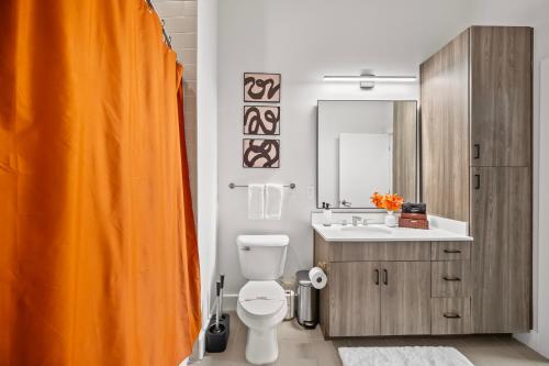 an orange shower curtain in a bathroom with a toilet at Haven Verde in Atlanta