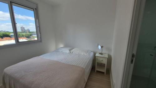 Next Residence في كامبيناس: غرفة نوم بيضاء مع سرير ونافذة