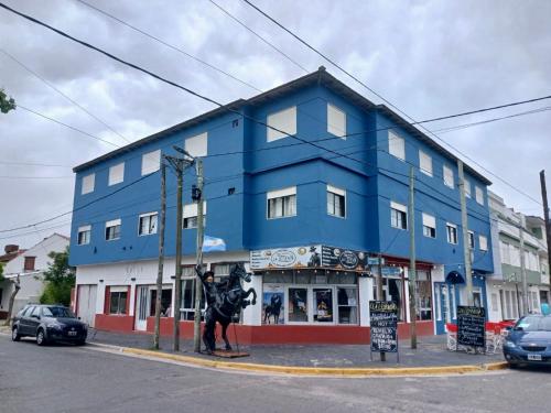 a blue building with a statue in front of it at Rocio Club de Mar in Mar del Tuyú