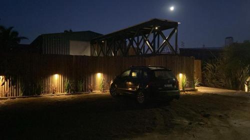 a car parked in front of a fence at night at Pedre Loft in La Pedrera