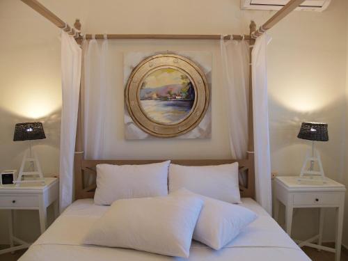 a bedroom with a bed with a painting on the wall at Melograno Apartments and Studios in Kala Nera