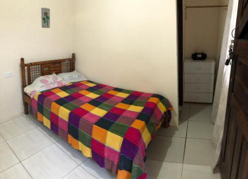 a bedroom with a bed with a colorful blanket at Hospedaje Maluli 09 in Santa Elena