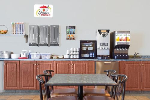 tavolo e sedie in cucina con bancone di Super 8 by Wyndham Portage La Prairie MB a Portage La Prairie