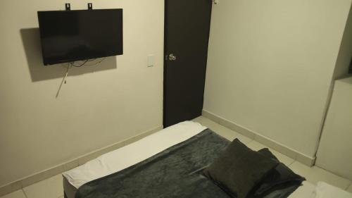 a bedroom with a bed with a television on the wall at 2 Habitaciones 2Aires Reservas SL in Cúcuta
