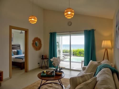 a living room with a couch and a view of the ocean at Amazing 2BR with private pool in Oyster Pond in Oyster Pond
