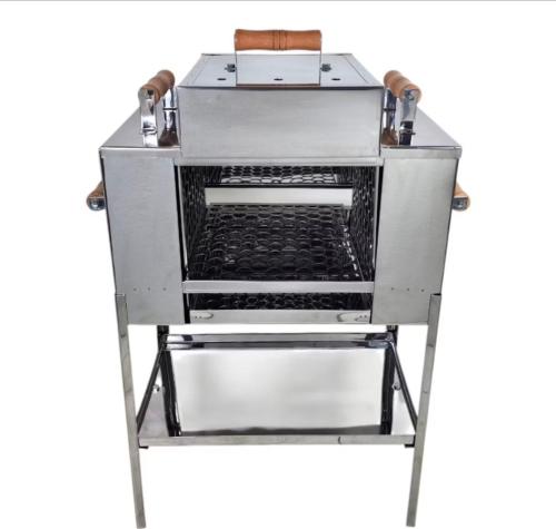 Un horno de metal sobre un soporte con la puerta abierta en Apartamento com vista para piscina com hidromassagem e aquecedor, en Cataguases