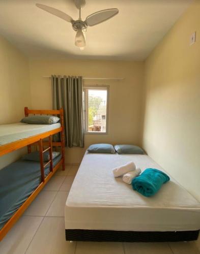a bedroom with two bunk beds and a window at Porto Pousada com café in Imbituba