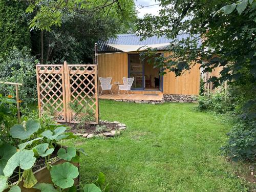 un jardín con una valla y una casa en Tinyhouse v zahradě, 