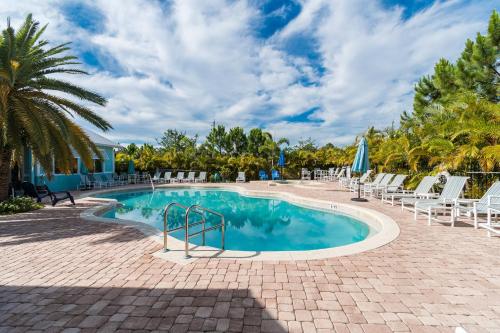 una piscina con sedie e una palma di 3BR Townhouse CC-5-103 a Indianola