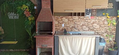 a outdoor kitchen with a stone wall and a table at Garden JP in João Pessoa
