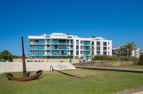 a large white building with a large iron boat in the grass at Aparthotel Caprice Skyline in Ciutadella