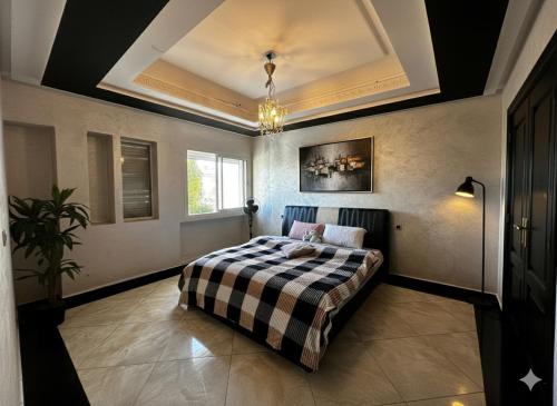 a bedroom with a bed with a checkered blanket at Luxury Villa with pool 6 min to Football Stadium CAF in Rabat