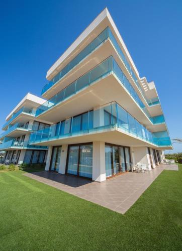 a large building with a lawn in front of it at Aparthotel Caprice Skyline in Ciutadella