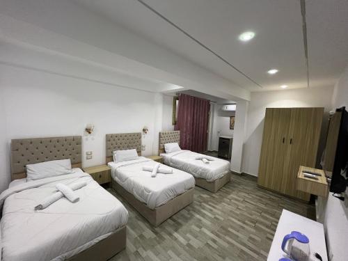 a hotel room with two beds and a television at khufus pyramids view INN in Cairo