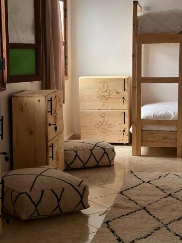 a bedroom with two bunk beds and two ottomans at Tamonda in Tamraght Ouzdar