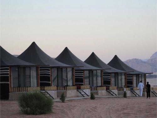 a building with black roofs in the desert at Wadi Rum Bubbles Wissam camp in Wadi Rum