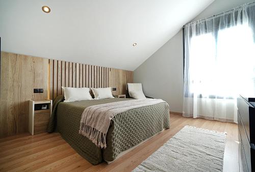 una camera da letto con un letto e una grande finestra di GALIHOST - Villa Gandara a Ribadumia