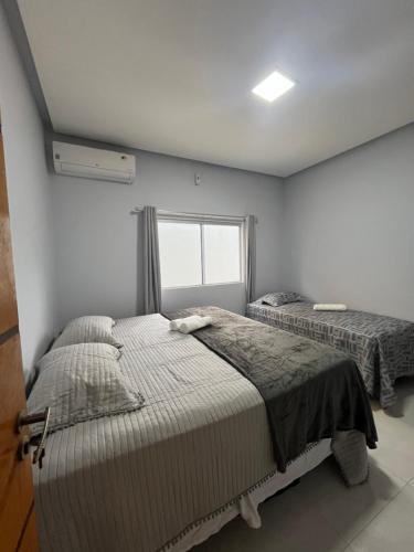 een slaapkamer met twee bedden en een raam bij Impera House Casa com piscina in Imperatriz