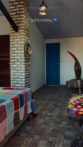 a room with a bed and a blue door at Pousada Castelo do Gaúcho in Baía Formosa