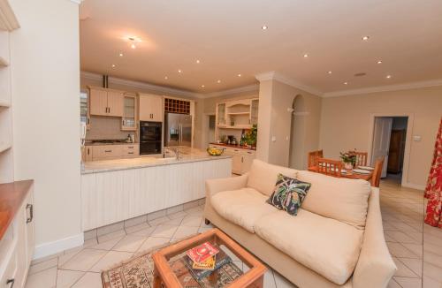 un soggiorno con divano e cucina di Charming Historic Home in Central Stellenbosch a Stellenbosch