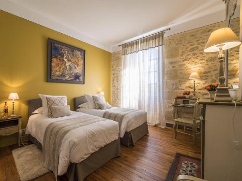 a hotel room with two beds and a desk at La Sauternaise, luxury Boutique B&B in Sauternes