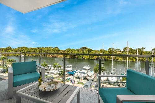 een balkon met stoelen en een tafel en uitzicht op een jachthaven bij Waterfront Captains Stateroom CC-506 in Indianola