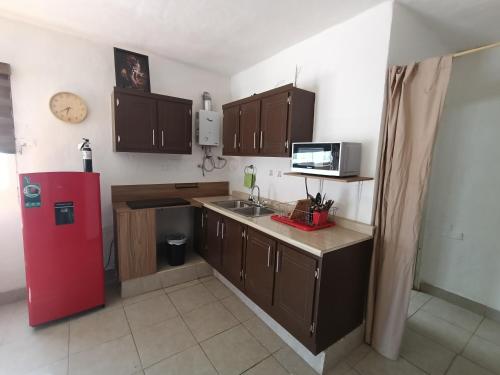 a kitchen with a red refrigerator and wooden cabinets at Departamento cerca del aeropuerto in Chihuahua