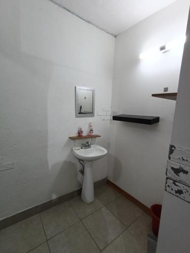 a white bathroom with a sink and a mirror at Departamento cerca del aeropuerto in Chihuahua