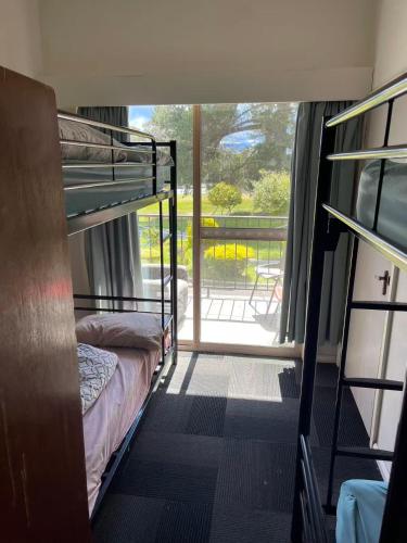 a room with two bunk beds and a balcony at sj hostel in Legana